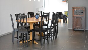A dining area with a wooden table and black chairs, a blue vase, and a cabinet with multiple drawers. - Farmhouse Retreat, Fernelmont (Forville)