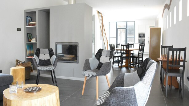 A modern living room with a fireplace, a dining area, and a large window. - Farmhouse Retreat, Fernelmont (Forville)