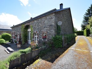 A stone building with a sloped roof, a small porch, and a sign reading "Gîte."