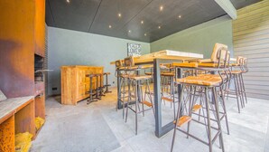 Un área de bar moderna con taburetes altos y una barra de madera.