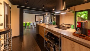 A modern kitchen with a central island, stainless steel appliances, and a view of the dining area.