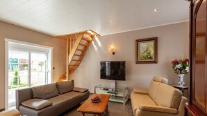 Ein modernes Wohnzimmer mit einer Couch, einem Couchtisch, einem Fernseher und einer Treppe.