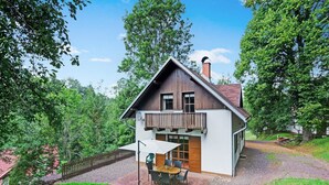 A two-story house with a wooden balcony, a gravel driveway, and a grassy yard. - Mountains Family Retreat (Rudník)