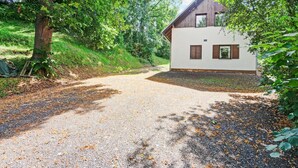 A house with a gravel driveway, surrounded by trees and greenery. - Mountains Family Retreat (Rudník)