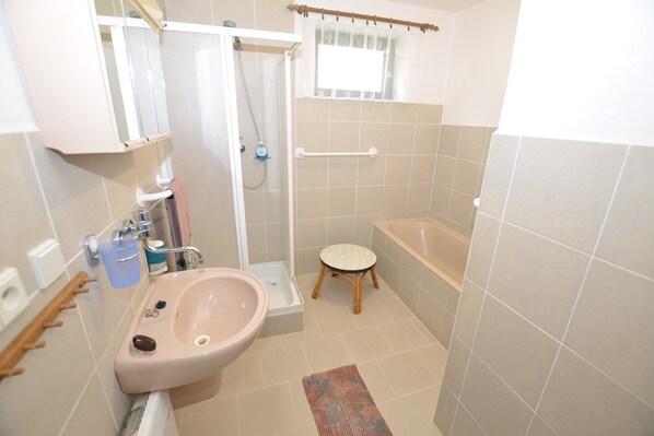 A bathroom with a sink, toilet, shower, and bathtub.