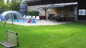 A backyard with a swimming pool, a covered patio area, and a target on the wall. - Villa in Zelenecká Lhota with Private Pool (Liban)