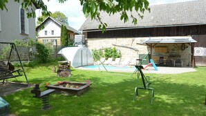 A backyard with a swimming pool, a barbecue area, and a swing set. - Villa in Zelenecká Lhota with Private Pool (Liban)