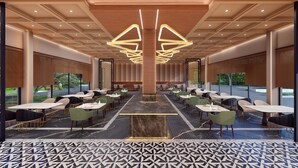 A spacious indoor dining area with multiple tables and chairs, a central column, and a patterned floor. - Tree of Life Amara Resorts & Spa Udaipur (Udaipur)