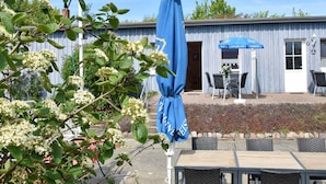 A building with a blue awning and outdoor seating area. - Gemütlicher Aufenthalt am Wieker Hafen (Wiek auf Rügen)
