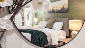 A bedroom with a bed, pillows, a lamp, and a painting on the wall. - Home with Backyard Fun: Hot Tub, Golf, BBQ, Games! (Phoenix)