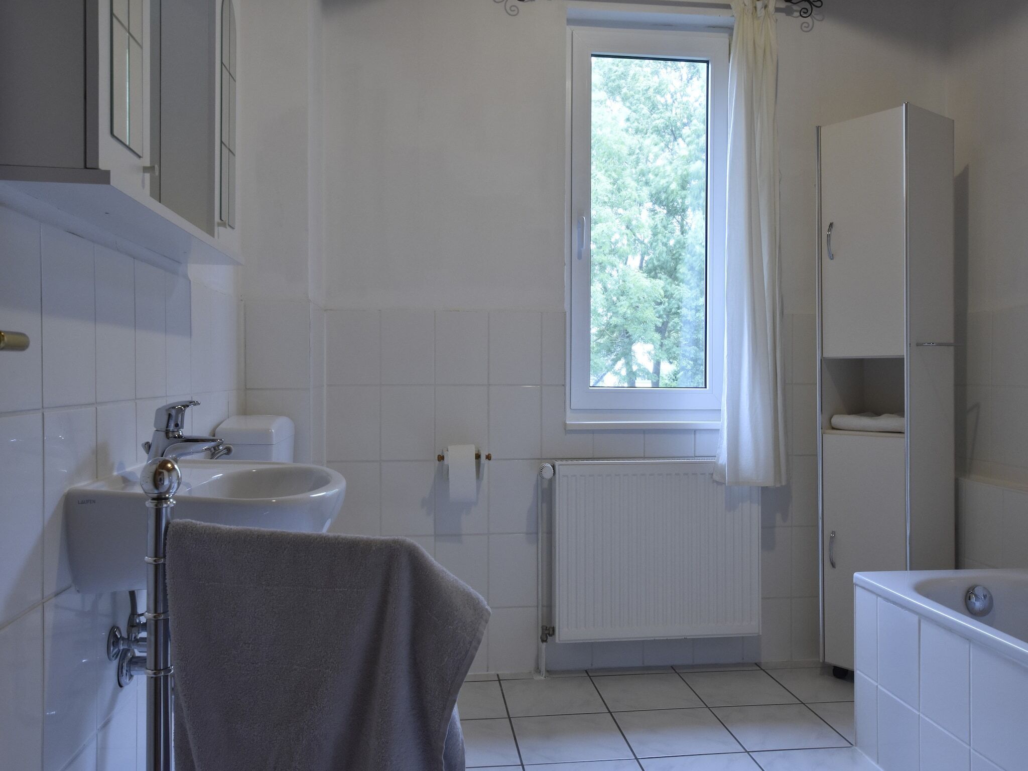 A bathroom with a toilet, sink, and bathtub.