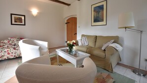 A living room with a sofa, armchair, coffee table, and a lamp. - Schicke Ferienwohnung in der Nähe der Ostseeküste (Gerdshagen)