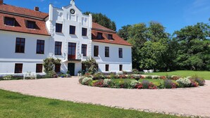 A large white building with a red-tiled roof, multiple windows, and a central entrance. - Wohnung nahe Ostsee Kühlungsborn (Gerdshagen)