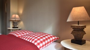 Una camera d'albergo con un letto, due comodini e due lampade.