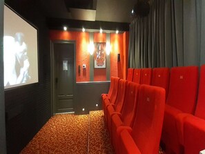 A movie theater with red seats, a screen, and a Star Wars poster on the wall. - Exklusives Gruppenhaus mit home cinema (Treuen)