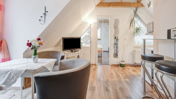 Un appartement moderne de style « loft », comprenant un coin repas, un espace de vie et une cuisine.