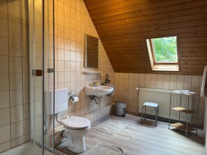 A bathroom with a toilet, sink, and shower.