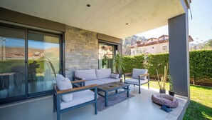 An outdoor patio with a sofa set, a coffee table, and a pet bed.