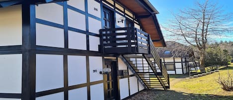 Un edificio tradicional de entramado de madera con una escalera visible que lleva a la entrada.