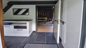 Een moderne badkamer met een wit wastafelmeubel, donkere tegels en een plafondventilator.
