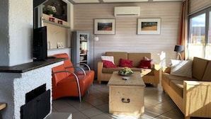 A modern living room with a fireplace, a sofa set, a coffee table, and a television. - Holiday home in Reimboldshausen with balcony (Kirchheim/Seepark)