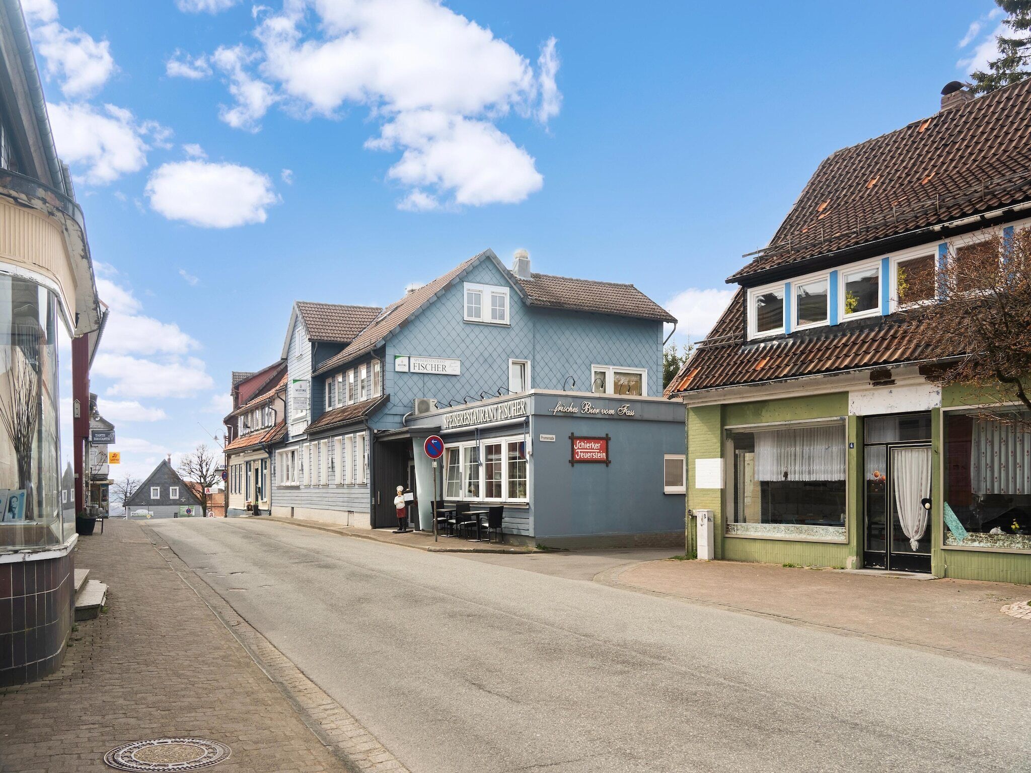 A street view with a blue building labeled 'FISCHER' and a green building with a sign 'Jägermeister'.