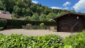 A rural setting with a wooden barn, a fenced area, and lush greenery. - Holiday home with sauna in the Eifel National Park (Schleiden)