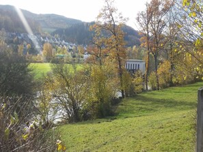 A rural landscape with a grassy field, trees with autumn foliage, and a building in the background. - Ferienwohnung in Wehrstapel (Meschede)