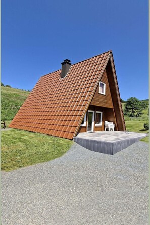 A house with a sloped roof, a small porch, and a window.