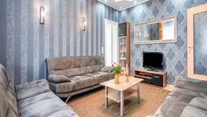 A modern living room with a grey sofa, a wooden coffee table, and a flat-screen TV. - Spacious Villa near Center (Medebach)