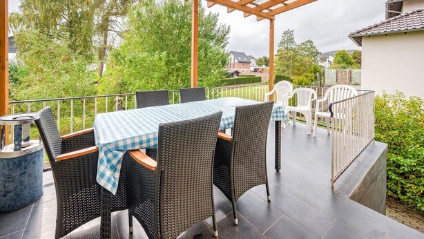 An outdoor patio with a covered seating area, featuring a table and chairs. - Spacious Villa near Center (Medebach)
