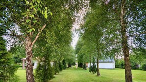 A well-maintained garden with a pathway leading to a building. - Spacious and Comfortable Holiday Homes With Pool (Darlowo)