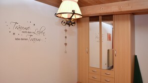 A bedroom with a bed, a wardrobe, and a wall with a motivational quote. - Ferienwohnung in Bad Bayersoien (Bad Bayersoien)