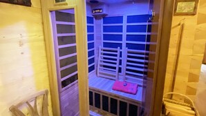 A sauna with wooden benches and a bench with a pink towel. - Bayerisches Refugium mit Sauna (Tittmoning)