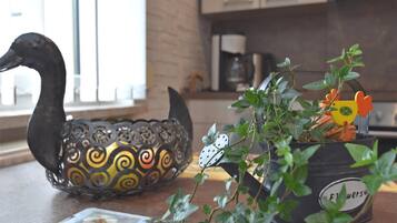 A kitchen counter with a decorative metal swan, a potted plant with a flower pot, and a magazine.