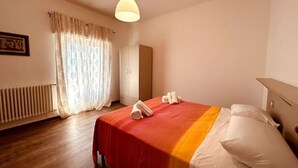 A hotel room with a bed, a radiator, a wardrobe, and a hanging light fixture. - The "Cenerone" - Comfort and Relax, discover sea and country, feel our culture (Borgo Santa Maria Immacolata)