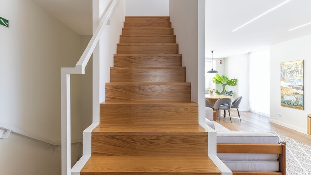A wooden staircase with white railings leading to a dining area with a table and chairs. - Mexia Galvao - City Center, Mexia Galvão - City Center (Viana do Castelo)