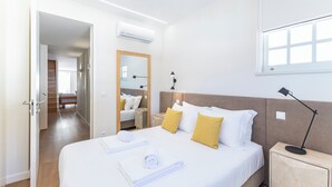 A hotel room with a bed, a bedside table, a lamp, a mirror, and a window. - Mexia Galvao - City Center, Mexia Galvão - City Center (Viana do Castelo)