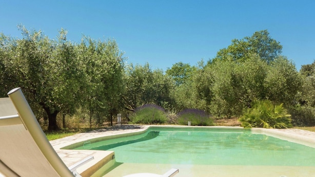 A pool with a lounge chair and a stone patio. - Holiday Home in Béziers with Pool and Vineyard (Murviel les Béziers)