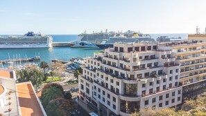 A coastal cityscape with modern buildings, a marina with cruise ships, and a clear view of the sea. - Tropical Sun by Atlantic Holiday (Funchal)
