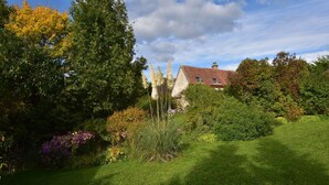 A house surrounded by lush greenery and flowering plants.