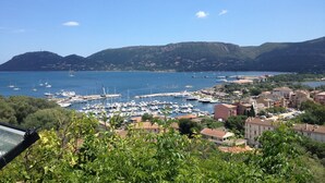 A marina with boats, a town with buildings, and hills in the background. - Holiday Home in Moriani-Plage near Beach (Moriani Plage)