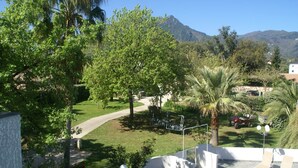 A pool area with lounge chairs, a pathway, and surrounding greenery. - Holiday Home in Moriani-Plage near Beach (Moriani Plage)