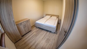 Une chambre à coucher avec un lit, une armoire en bois et une table de chevet.