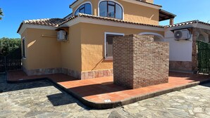 A two-story house with a tiled roof, a brick chimney, and a stone foundation. - Villa Pinna (San Teodoro)