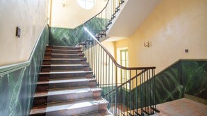 Un escalier avec des marches en marbre et une rampe incurvée.