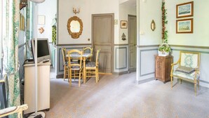 Un coin repas comprenant une table et des chaises, un téléviseur et un meuble.