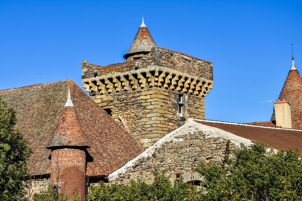 A historic stone building with a prominent tower and a smaller adjacent structure.