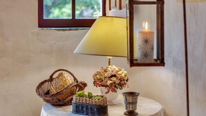 A table with a lamp, a basket, a flower arrangement, and a candle.
