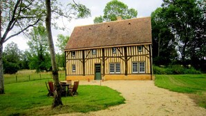 A traditional half-timbered house with a dirt path leading to a wooden door. - Historic Home Saint-Aignan by Lake (Saint-Aignan)